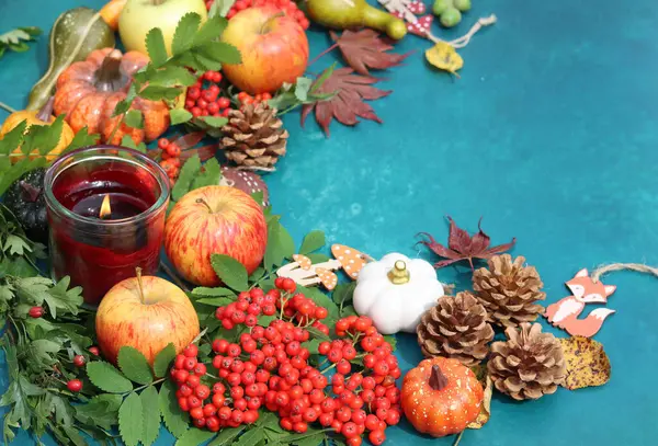 Fotokopi alanı ile canlı mavi arka planda balkabakları, elmalar ve rowan ile sonbahar kompozisyonu. Masadaki çevre dostu sonbahar süslemeleri. 