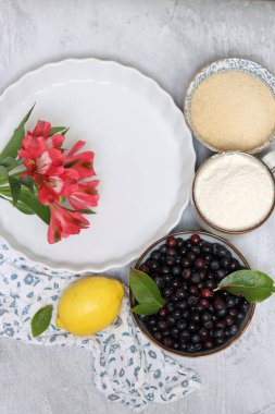 Pasta yapmak için gereken malzemeler: un, yumurta, şeker, limon, yabanmersini. Işık arkaplan, üst görünüm, kopyalama alanı