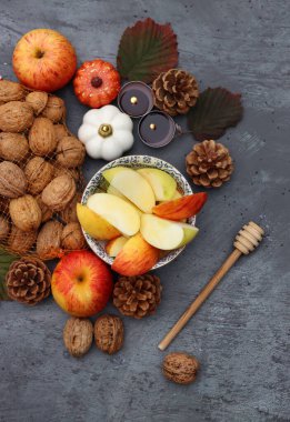 Elmalar, fındıklar, kırmızı yapraklar ve mumlarla dolu bir sonbahar. Metin için alanı olan desenli arkaplan. 