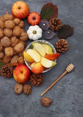 Rosh Hashanah en üstteki fotoğrafı simgeliyor. Kırmızı elmalar, tatlım. Dekorasyon ve mumlar. Arka planda fotokopi alanı var. İsrail kültürü konsepti. 