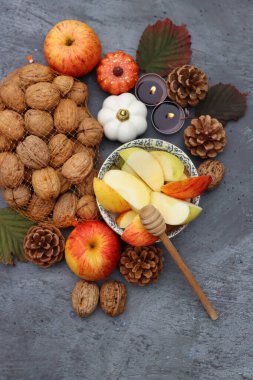 Elmalar, fındıklar, kırmızı yapraklar ve mumlarla dolu bir sonbahar. Metin için alanı olan desenli arkaplan. 