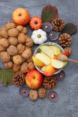 Rosh Hashanah en üstteki fotoğrafı simgeliyor. Kırmızı elmalar, tatlım. Dekorasyon ve mumlar. Arka planda fotokopi alanı var. İsrail kültürü konsepti. 