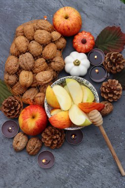 Elmalar, fındıklar, kırmızı yapraklar ve mumlarla dolu bir sonbahar. Metin için alanı olan desenli arkaplan. 