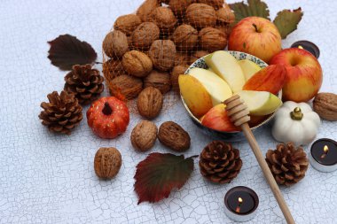 Elmalar, fındıklar, kırmızı yapraklar ve mumlarla dolu bir sonbahar. Metin için alanı olan desenli arkaplan. 