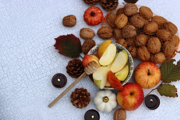 Elmalar, fındıklar, kırmızı yapraklar ve mumlarla dolu bir sonbahar. Metin için alanı olan desenli arkaplan. 