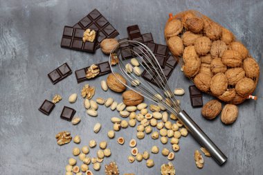 Gri arka planda çikolata, ceviz ve fındık..