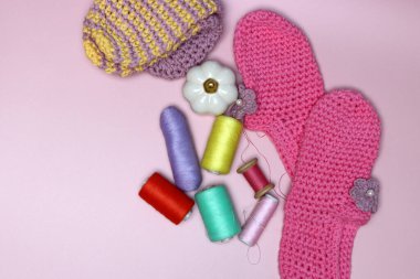 Pembe arka planda örülmüş giysiler ve aksesuarlar..