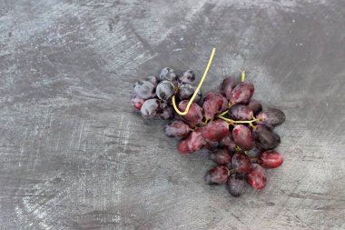 Gri arkaplandaki üzümler, üst görünüm, kopyalama alanı. Sağlıklı yeme kavramı. 