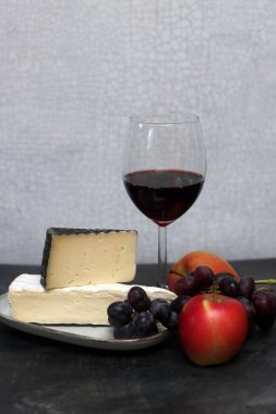 Bir bardak kırmızı şarap, peynirli, üzümlü ve elmalı.. 