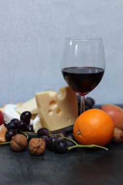 Bir bardak kırmızı şarap, peynirli, üzümlü ve elmalı.. 