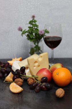 Bir bardak kırmızı şarap, peynirli, üzümlü ve elmalı.. 