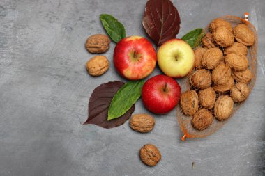 Gri arka planda kırmızı elmalar ve sonbahar yaprakları. Üst görünüm, alanı kopyala