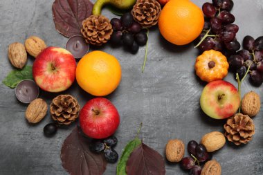 Gri arka planda meyve ve yapraklarla sonbahar kompozisyonu, üst manzara. Sağlıklı yeme kavramı. 