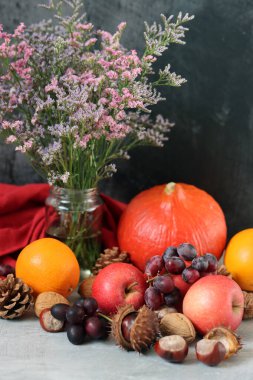 Comfort food ingredients on a table. Colorful still life with pumpkin, apples, nuts and flowers. Autumn harvest concept.  clipart