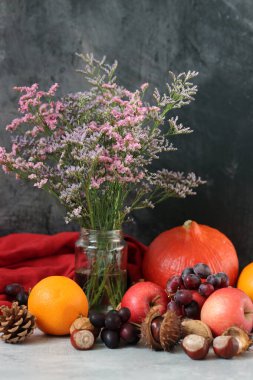 Masanın üzerinde rahatlatıcı yemek malzemeleri var. Balkabağı, elma, fındık ve çiçeklerle dolu renkli bir hayat. Sonbahar hasat konsepti. 
