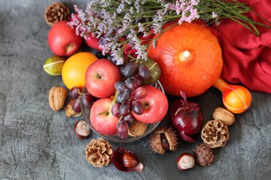 Masanın üzerinde rahatlatıcı yemek malzemeleri var. Balkabağı, elma, fındık ve çiçeklerle dolu renkli bir hayat. Sonbahar hasat konsepti. 