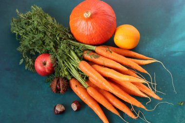 Organik tarım meyveleri ve sebzeler masada. Havuç, balkabağı, elma ve portakal manzaralı. Sonbahar yiyecekleri.. 