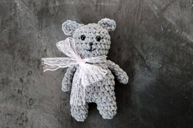 El yapımı, gri bir arka planı olan el yapımı bir oyuncak ayı.