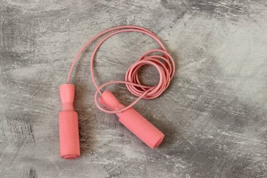 Pembe bir arka planda ip atlama. Fitness ve sağlıklı yaşam tarzı konsepti. 