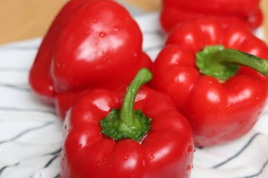 Kırmızı dolma biberler kapanıyor. Yüzeyin derinliği. Taze sebzeler masada.. 