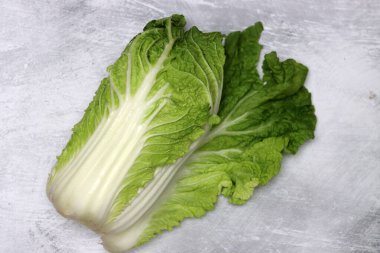 Gri arka planda taze Çin lahanası, üst manzara. Sağlıklı yemek.