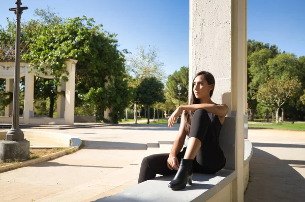 Mujer Joven Morena Delgada Vestida Negro Sentada Banco Con Mirada — Foto de Stock