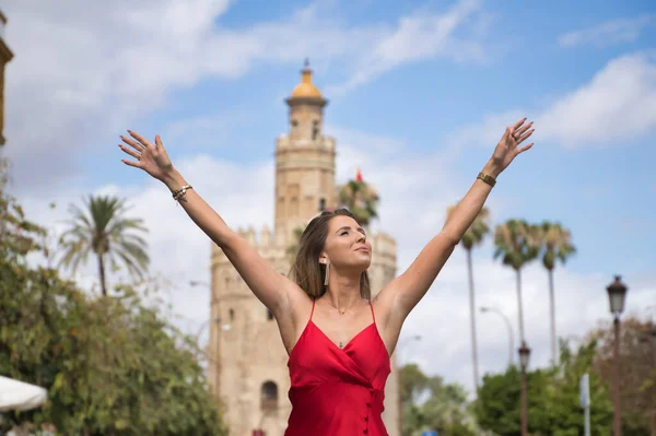 Genç, çekici, sarışın, zarif kırmızı parti elbisesi içinde, mutlu, kolları açık, bir Avrupa şehrinin ortasında yürüyor. Güzelliği, modayı, zarafeti, lüksü, seyahati kavra.