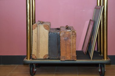 Detail of old travel suitcases on the luggage trolley at the reception of a luxurious hotel. Travel concept, rooms, buildings, interior design.