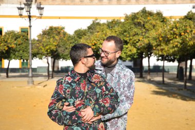 Real marriage portrait of gay couple, hugging, smiling and happy looking at each other. Concept lgtb, lgtbiq+, couples, in love, love.