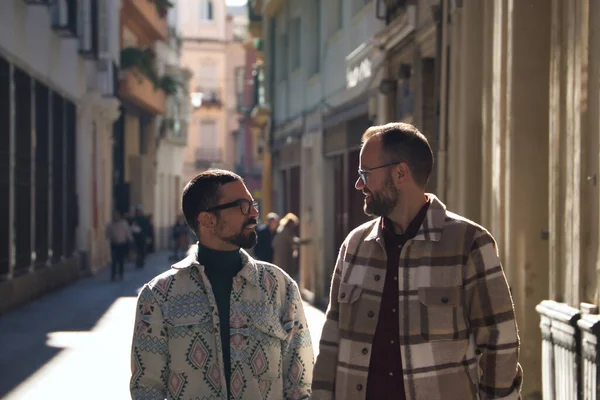 Real marriage of gay couple, walking around the city, holding hands, talking with accomplice attitude. Concept lgtb, lgtbiq+, couples, in love, love.