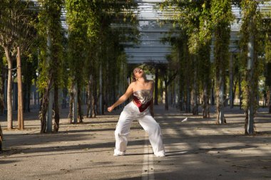 Latin ve İspanyol kız, genç ve güzel, açık havada dans eden modern dans. Dans konsepti, ay yürüyüşü, zıplama stili, karıştırma, elektrodans, hip hop, funky, popping.