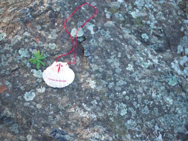 Compostela 'lı Santiago' nun arması ile birlikte yolun ortasındaki büyük bir kayaya yerleştirilmiş bir kabuğun ayrıntıları. Kabukta 