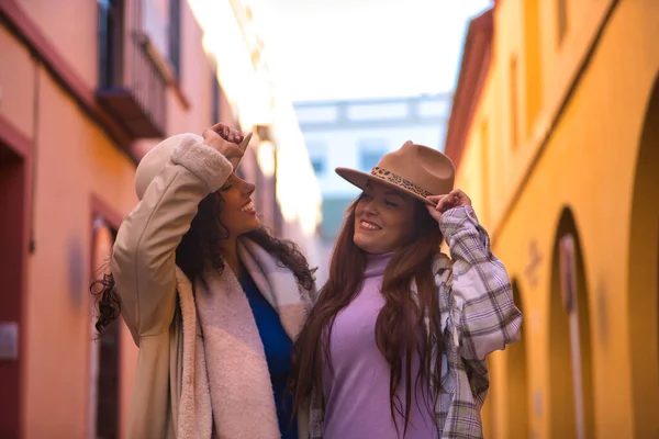 Duas Mulheres Jovens Bonitas Vestindo Chapéus Casacos Abraçadas Olhando Uma — Fotografia de Stock