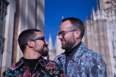Real marriage portrait of gay couple, hugging, smiling and happy looking at each other. Concept lgtb, lgtbiq+, couples, in love, love.