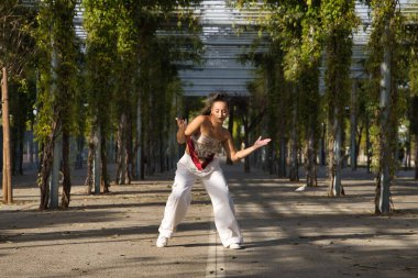Latin ve İspanyol kız, genç ve güzel, açık havada dans eden modern dans. Dans konsepti, ay yürüyüşü, zıplama stili, karıştırma, elektrodans, hip hop, funky, popping.
