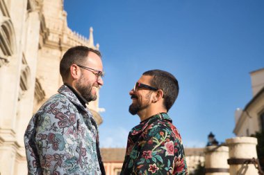 Real marriage portrait of gay couple, hugging, smiling and happy looking at each other. Concept lgtb, lgtbiq+, couples, in love, love.