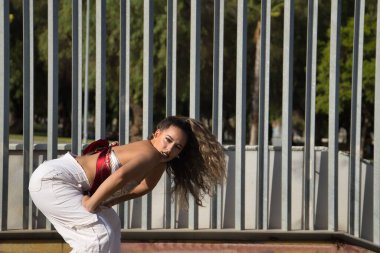 Latin ve İspanyol kız, genç ve güzel, açık havada dans eden modern dans. Dans konsepti, ay yürüyüşü, zıplama stili, karıştırma, elektrodans, hip hop, funky, popping.