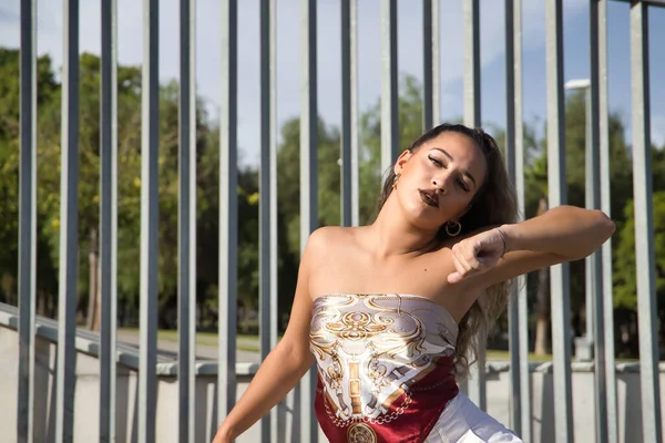Latin and Hispanic girl, young and beautiful, dancing modern dance in the street outdoors. Dance concept, moonwalk, jumpstyle, shuffle, electrodance, hip hop, funky, popping.