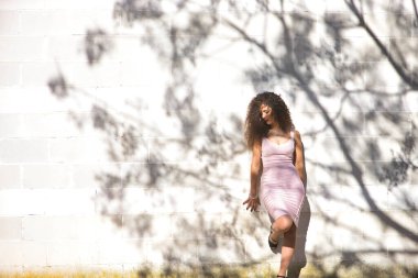 Genç bir kadın, güzel, esmer, kıvırcık saçlı, pembe elbiseli, bir ağacın gölgeleriyle beyaz bir duvara yaslanmış, üzgün, yalnız ve melankolik. Keder kavramı, üzüntü.