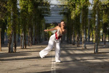 Latin ve İspanyol kız, genç ve güzel, açık havada dans eden modern dans. Dans konsepti, ay yürüyüşü, zıplama stili, karıştırma, elektrodans, hip hop, funky, popping.