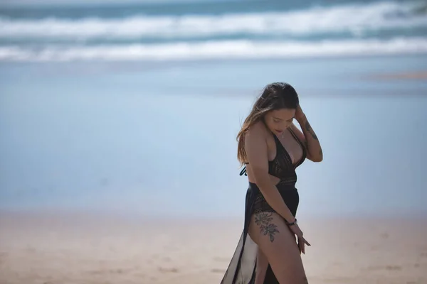 黒の水着とサロンで魅力的な若い女性は 孤独と静かで ビーチで歩いてください コンセプト静けさ — ストック写真