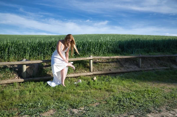 Genç Bir Kadın Güzel Sarışın Beyaz Elbiseli Tahta Bir Korkulukta — Stok fotoğraf