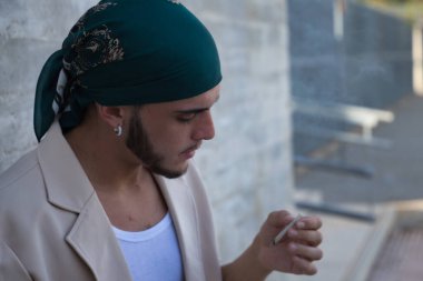 Latin ve İspanyol çocuk, genç ve uyumsuz, asi, kafasında mendili olan, kendi kendine sigara içen. Kavram tütün, duman, yangın, bağımlılık, çeteler.