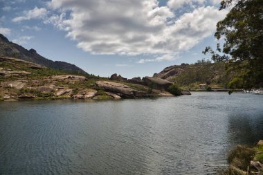Büyük kayalar ve Atlantik Okyanusu 'ndan gelen bulutlu mavi gökyüzü ile dağlık oluşumlu güzel bir manzara. Manzara konsepti, su, dağlar, bulutlar.
