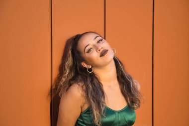 Latin and Hispanic girl, young and beautiful, with green eyes and large eyelashes, looking at the camera in a sensual and provocative attitude. Concept beauty, fashion, provocation, sensuality.