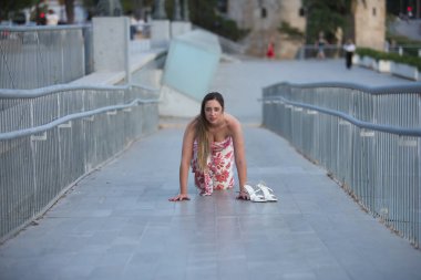 Kahverengi saçlı ve çiçekli elbisesi olan güzel bir genç kadın, bir girişimci, bağımsız ve yeni bir başlangıcı temsil eden bir koşuya çıkabilecek bir konumda. Güzelliği, modayı, eğilimi kavra.