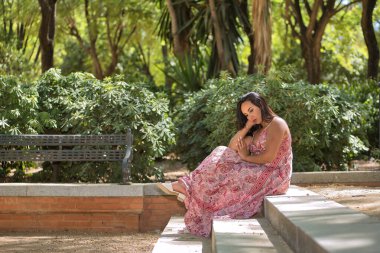 Faslı bir kadın, genç, güzel, koyu renk saçlı, kaşmir bir elbise giymiş, üzgün, yalnız, toplumun baskısı yüzünden depresyonda, bir parkın merdivenlerinde oturuyor. Etnik köken kavramı, çeşitlilik.