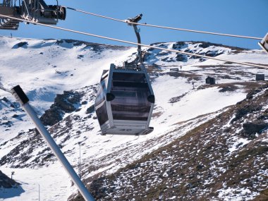 Kayak merkezinin tepesine giden teleferik asansörleri. Böylece kayakçılar ve snowboardcular yamaçtan inmeye başlayabilecekler. Karı, sporu, tatil köyünü, kışı.