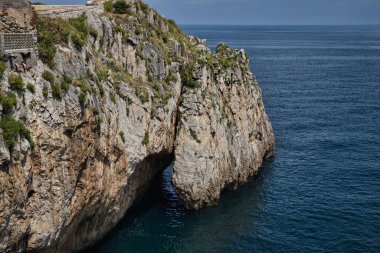 Castro Urdiales, güneşli bir günde sakin bir denizi olan doğal bir mağaranın oluşumuyla Cantabrian kıyısında uçurum. Konsept yerler, manzaralar, doğa.