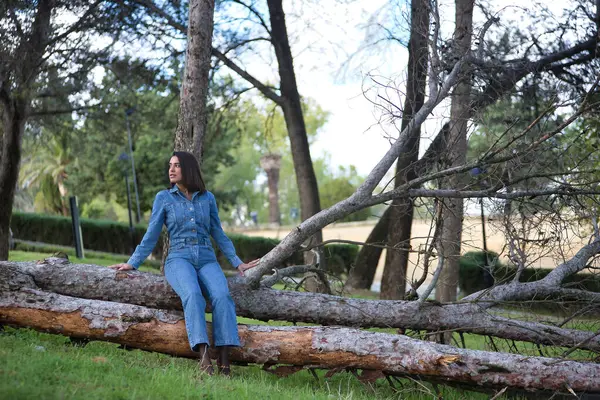 Genç, güzel, esmer, İspanyol bir kadın. Kot pantolon giyiyor. Dalgın ve dalgın. Kavram moda, güzellik, moda, kadınlık.